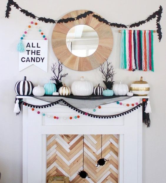 a colorful Halloween mantel with bright pompoms, tassels, pumpkins and various garlands