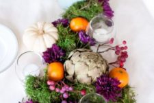 24 a Thanksgiving centerpiece with artichokes, white pumpkins, moss and purple berries and blooms