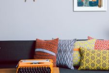 24 abstract pillows on the sofa make it bright and add a mid-century modern feel to it