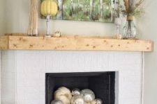 26 simple styling with a birch artwork, feathers, wheat, pumpkins and silver and white pumpkins in the fireplace