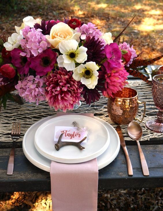the tablescape is influenced by a super lush and bold floral centerpiece in pink, fuchsia and neutrals