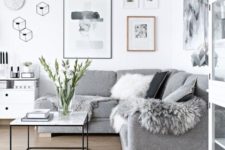 02 a Scandinavian living room done in white and greys, faux fur and pillows add coziness to the space