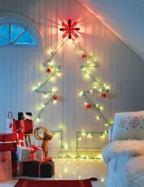 A cute wall mounted Christmas tree done with green lights and red and white ornaments for a traditional feel