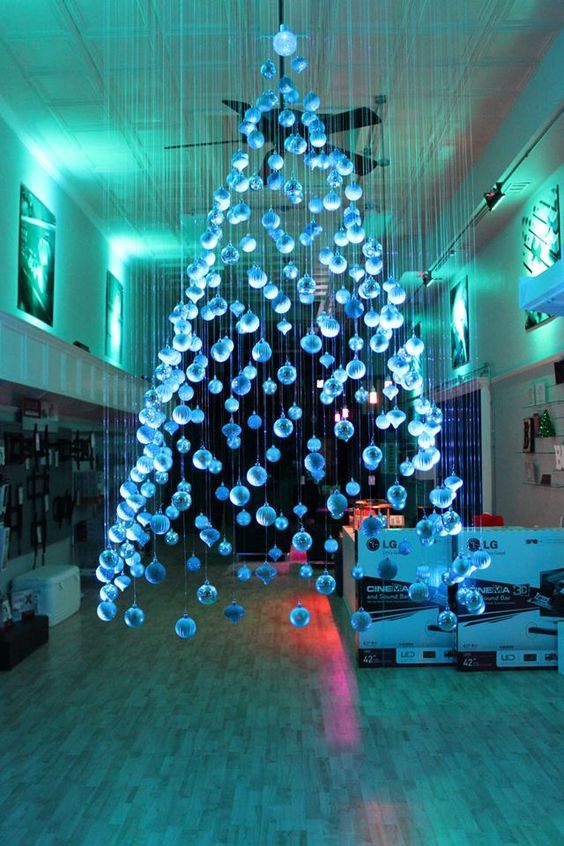a large and beautiful ice blue suspended Christmas tree of ornaments floating above the floor
