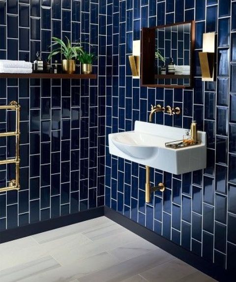 a navy tiled bathroom with white grout and gold fixtures looks timelessly elegant, gold metal features fit both masculine and feminine rooms