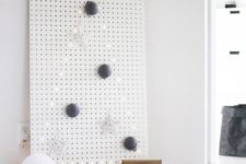 02 a white pegboard with a Christmas tree lined out with lights and with some ornaments