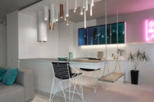 03 The kitchen island features a diing space and a swing as a seat