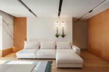 04 The living room is airy and light-filled, with a large sofa and wall lamps
