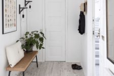04 a Scandinavian entryway with whitewashed floors and a cork bench feels minimal and airy