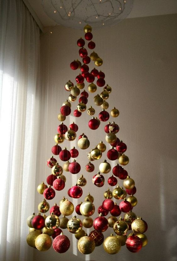 a chic Christmas tree of red and gold glitter, shiny and matte ornaments and lights above it