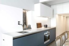 05 The minimalist kitchen features lower grey cabinets and white countertops, some more white storage units