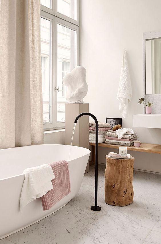 a contemporary bathroom with stone and wood, touches of blush and dusty pink for a girlish feel