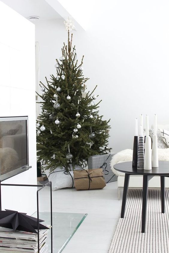 a modern Scandi Christmas tree with white, clear and metallic ornaments and no lights for a laconic look