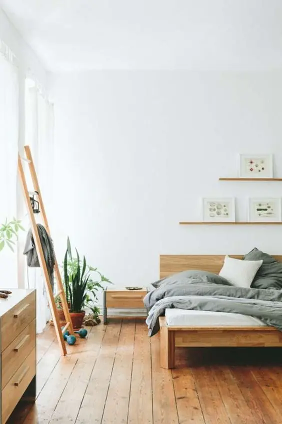this minimalist bedroom looks very warm and welcoming due to a large amount of wood used in decor