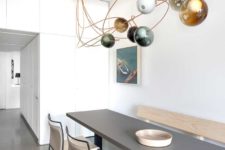 06 The dining space shows off a long grey table, comfy leather chairs and a gorgeous bubble lighting over the set