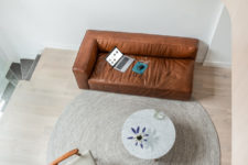 06 The sofa is a chic brown leather couch, which adds texture and chic to the space