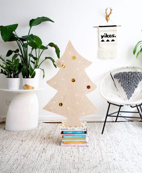 a cute plywood Christmas tree decorated withh lights and colorful and metallic stickers on it