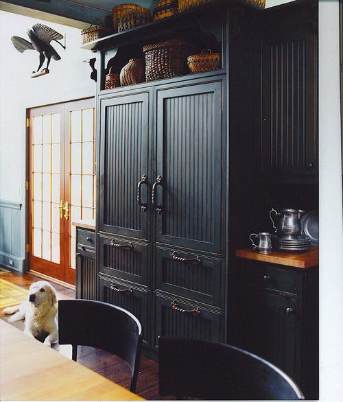 a fridge and freezer integrated into vintage kitchen decor featuring the same doors and handles