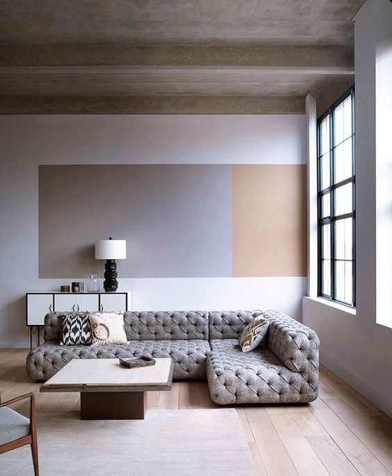 a neutral space done in greys and beige plus warm-colored wood on the floor and an accent on the wall