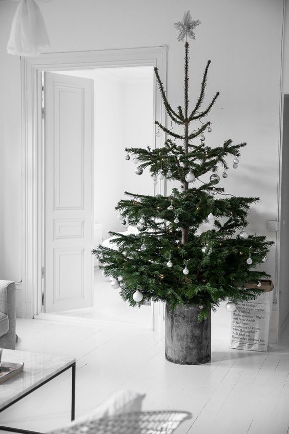 a Nordic Christmas tree with silver and white ornaments in a galvanized bucket is a chic idea for a modern space