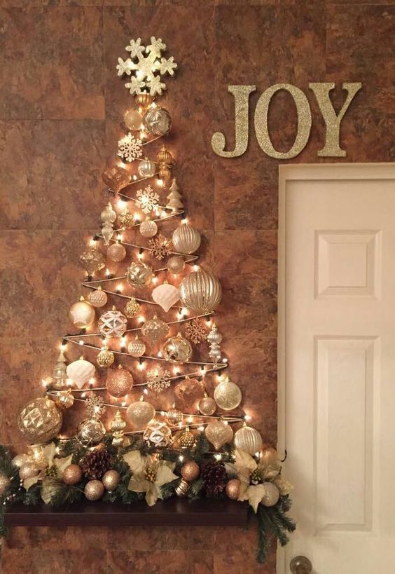 a glam wall-mounted Christmas tree done with lights and white and silver ornaments of various shapes over the mantel