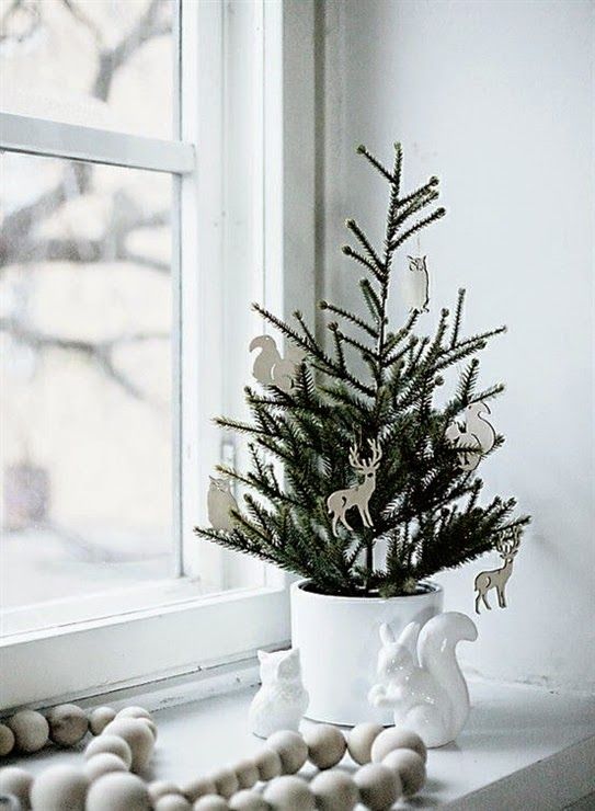 a planted Christmas tree in a white planter and with white plywood laser cut ornaments