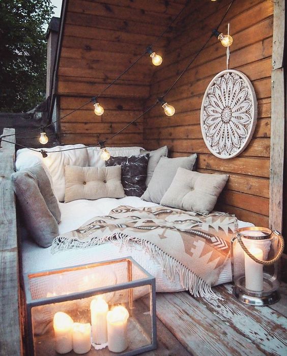 a small and cozy sofa, lots of pillows and throws, large candle lanterns and an oversized dream catcher