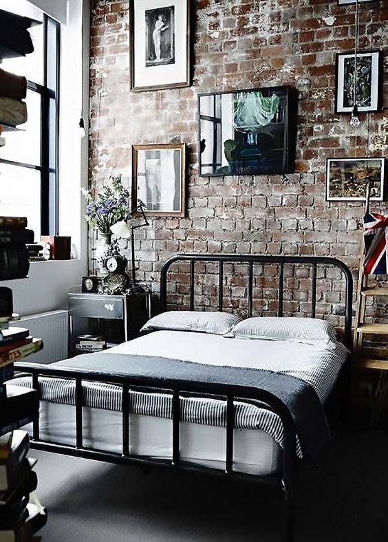 an industrial bedroom with an exposed brick statement wall, which is the centerpiece here