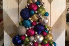 11 a chevron painted board and a colorful and glitter Christmas tree made of ornaments with a star on top