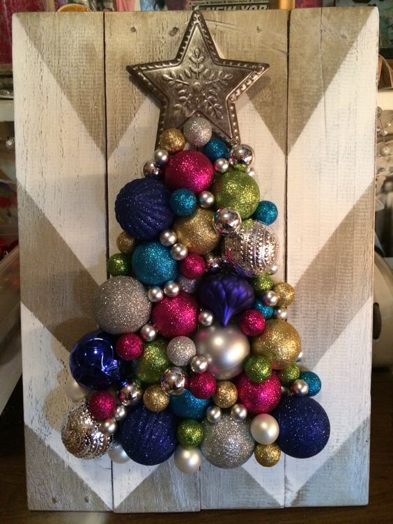 a chevron painted board and a colorful and glitter Christmas tree made of ornaments with a star on top