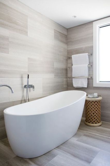a contemporary bathroom all clad with tiles and with a wooden coffee table - add textures for interest