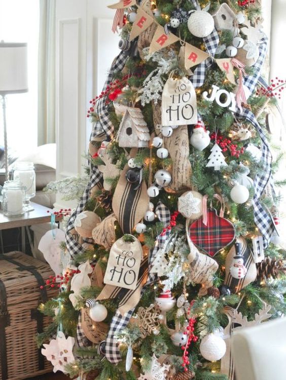 a gorgeous rustic meets traditional Christmas tree with jingle bells, burlap ornaments and buntings, plaid ribbons, yarn balls and fake berries