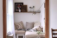 11 an L-shaped bench with upholstery, a couple of shabby side tables, a shelf and a sconce
