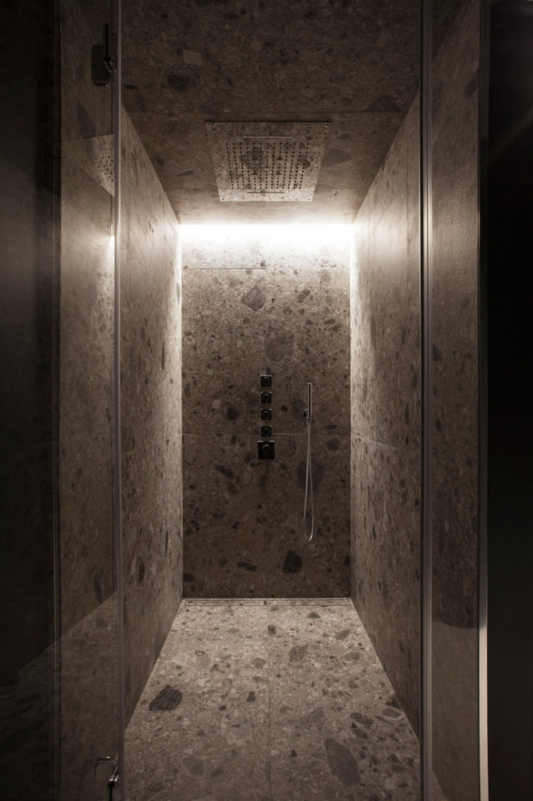 The second bathroom features a shower clad with stone