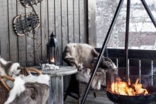 12 a cabin-style terrace with wicker chairs and a wooden table, faux fur and a large suspended fire bowl
