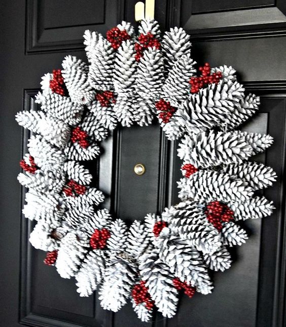 a snowy pinecone wreath with fake red berries is a bold idea for Christmas and it's very easy to make
