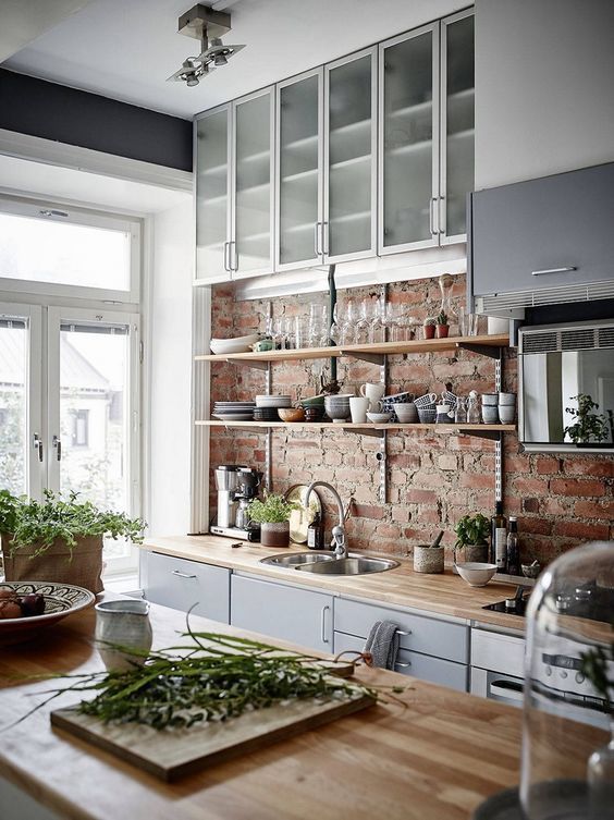 an exposed brick wall and wooden countertops for a modern rustic kitchen