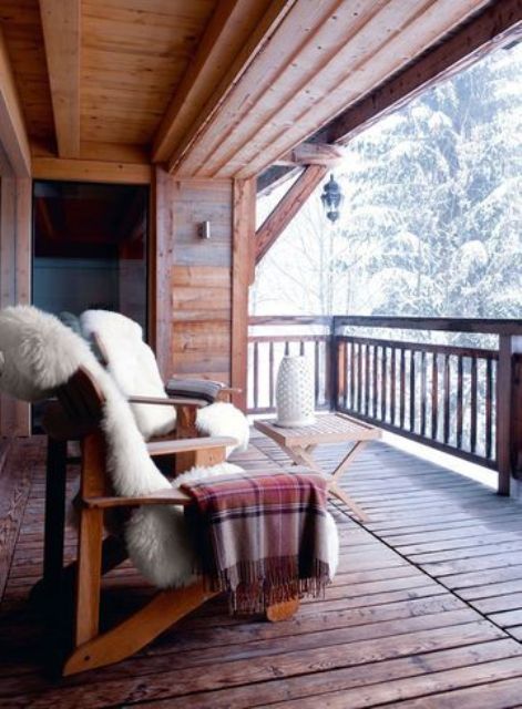 a couple of wooden chairs covered with faux fur, plaid blankets and a small folding table plus a gorgeous view