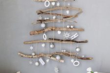13 a natural wall-mounted Christmas tree of various branches and with white and silver ornaments hanging down