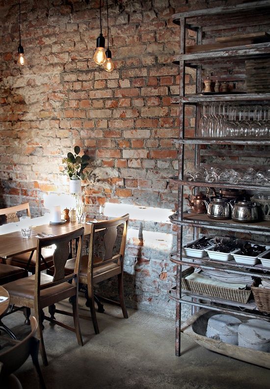 an exposed brick wall and vintage shabby metal furniture instantly make the dining room industrial