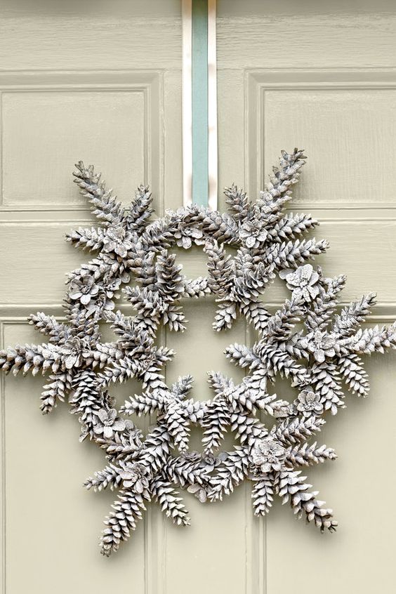a Christmas wreath made of snowy pinecones and ribbon is a super creative and interesting idea