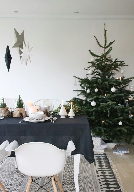A modern Scandi Christmas tree with white ornaments   stars, snowflakes and balls and some lights