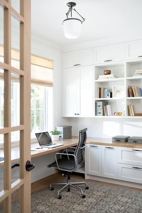 a neutral home office with light-colored wood incorporated and a rug and shades for more coziness