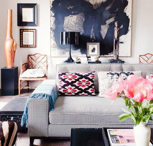 A neutral space is made more masculine with a large artwork and is made more feminine with printed pillows and light colroed metals