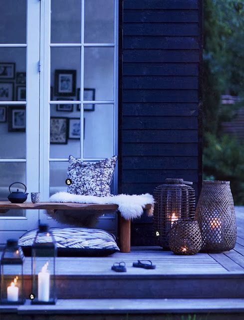 a Scandinavian space with lots of candle lanterns, pillows and faux fur for a real hygge feeling