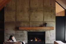17 a concrete fireplace wall, a metal mantel and a gable roof clad with wood