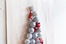 17 take a plywood sheet and attach some Christmas ornaments to it forming a Christmas tree and hang it on the wall