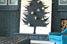 18 a plywood sheet with a Christmas tree painted in black on it and some ornaments attached