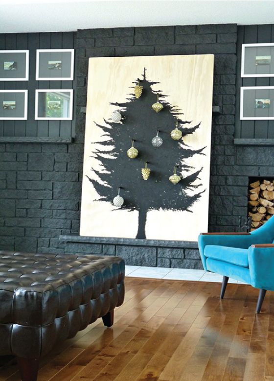 a plywood sheet with a Christmas tree painted in black on it and some ornaments attached