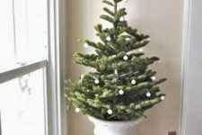 18 a small tree in a vintage urn decorated with tiny white ornaments – you won’t need more for a catchy look